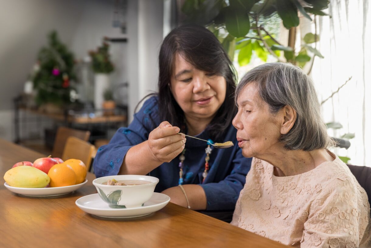 Learning how to prepare your home for hospice care, focusing on comfort, dignity, and support for caregiver feeding home hospice care patient at table.